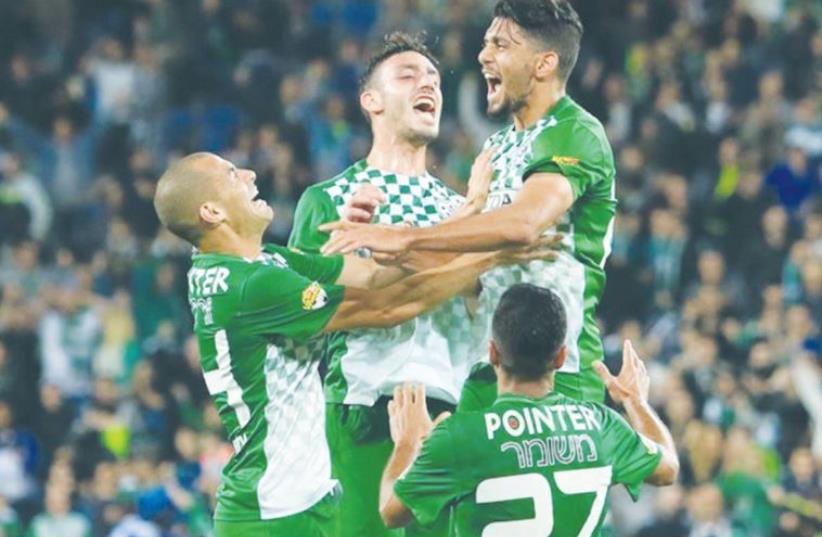 Maccabi Haifa midfielder Ataa Jaber (right) celebrates with teammates after scoring his side’s second goal in last night’s 3-2 win over Hapoel Haifa. (photo credit: ERAN LUF)