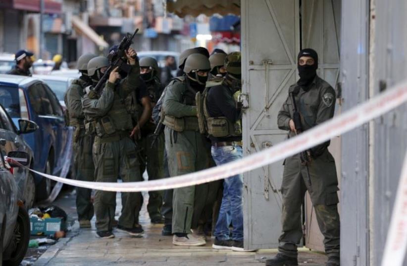 Israeli security forces search the scene where a Palestinain shooting attack on Israeli policemen took place just outside Jerusalem's Old City (photo credit: REUTERS)