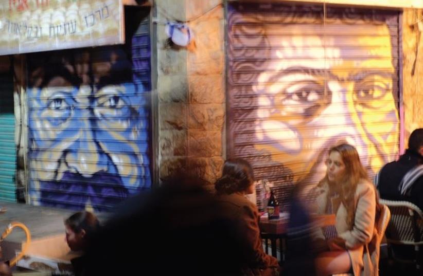 Solomon Souza’s portraits stare out at the Mahaneh Yehuda bustle (photo credit: RAFI KOEGEL)