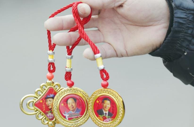 A man sells souvenirs bearing the images of China’s President Xi Jinping (right) and late chairman Mao Zedong at Tiananmen Square in Beijing last week (photo credit: REUTERS)