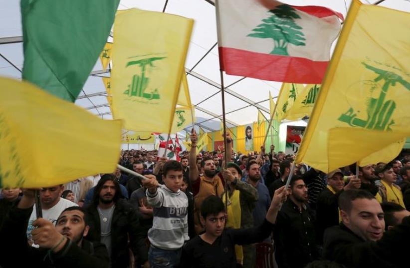 Supporters of Lebanon's Hezbollah leader Hassan Nasrallah wave Hezbollah and Lebanese flags in south Lebanon (photo credit: REUTERS)