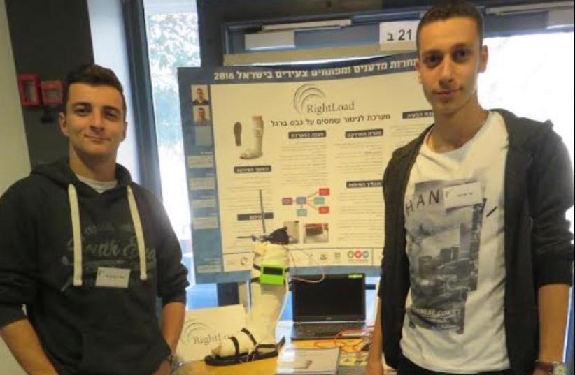 Shahar Ein-Kedem (left) and Bar Arama of Kiryat Tivon show project on device to sleep up healing of fractured legs in cast. (photo credit: JUDY SIEGEL-ITZKOVICH)