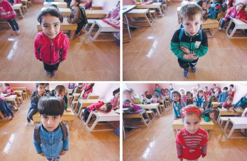 FIVE-YEAR-OLD pupils pose in a classroom last week in the rebel-controlled area of Maarshureen village in Idlib province. March 15 marks the fifth anniversary of the protests against President Bashar Assad that led to the devastating conflict in the country. (photo credit: KHALIL ASHAWI / REUTERS)