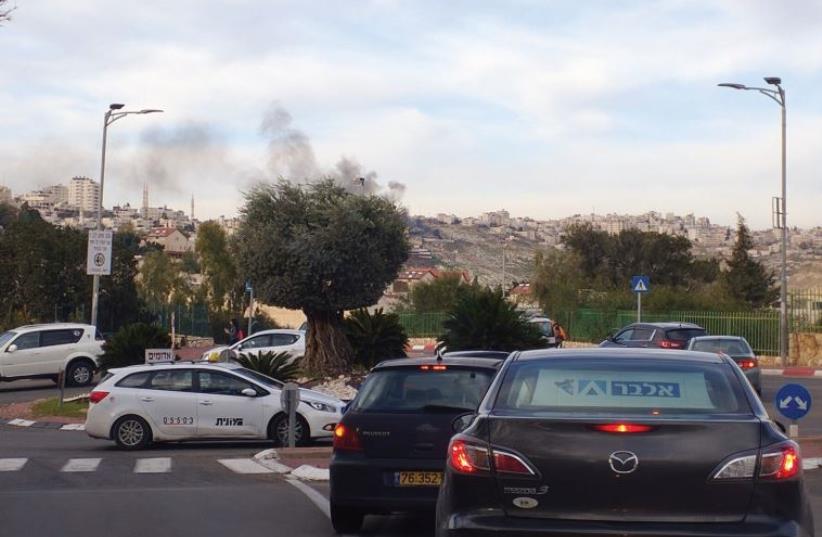 Smoke can be seen rising over the trees as one looks from Ma’aleh Adumim towards Eizariya (photo credit: PAULA STERN)