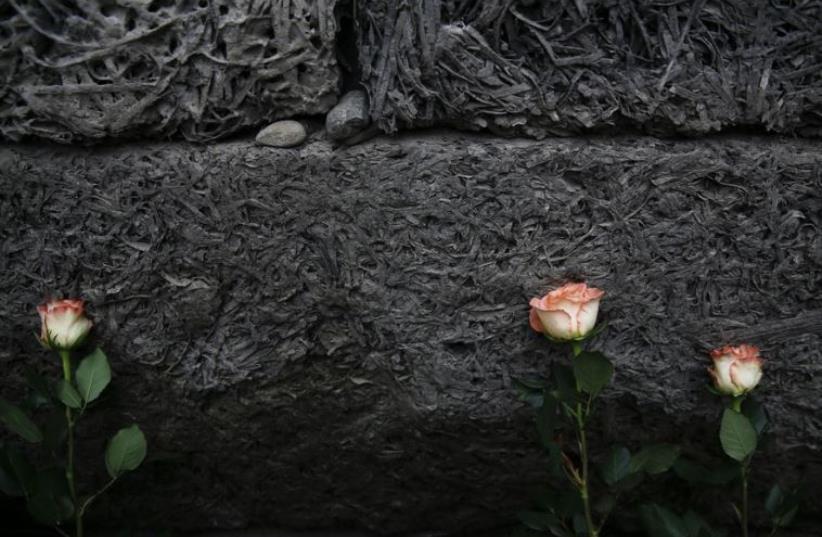 Flowers are placed at the "death wall" at the former Nazi German concentration and extermination camp Auschwitz-Birkenau in Oswiecim, Poland (photo credit: REUTERS)