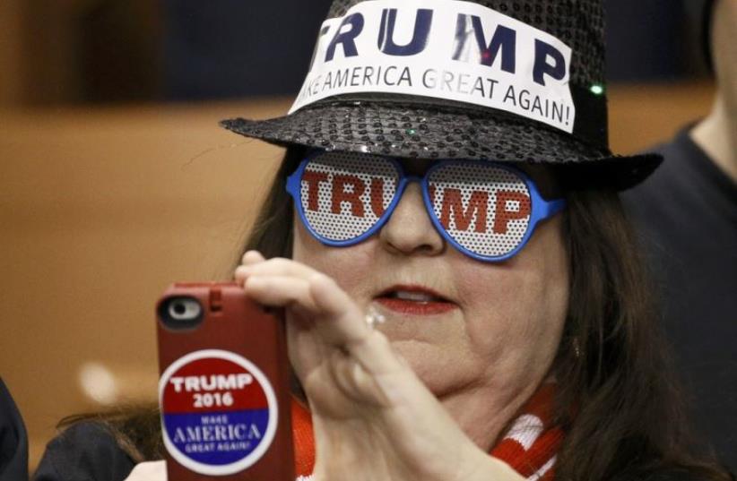 A supporter of Republican presidential candidate Donald Trump takes a photograph at a Trump campaign rally in New Hampshire (photo credit: REUTERS)