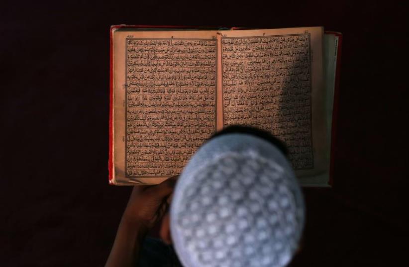 An Afghan boy reads the Koran in a madrasa, or religious school, during the Muslim holy month of Ramadan in Kabul June 30, 2014 (photo credit: REUTERS/MOHAMMAD ISMAIL)