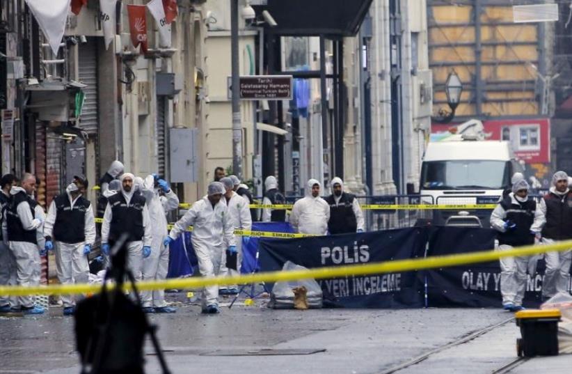 Police forensic experts inspect the area after a suicide bombing in Istanbul