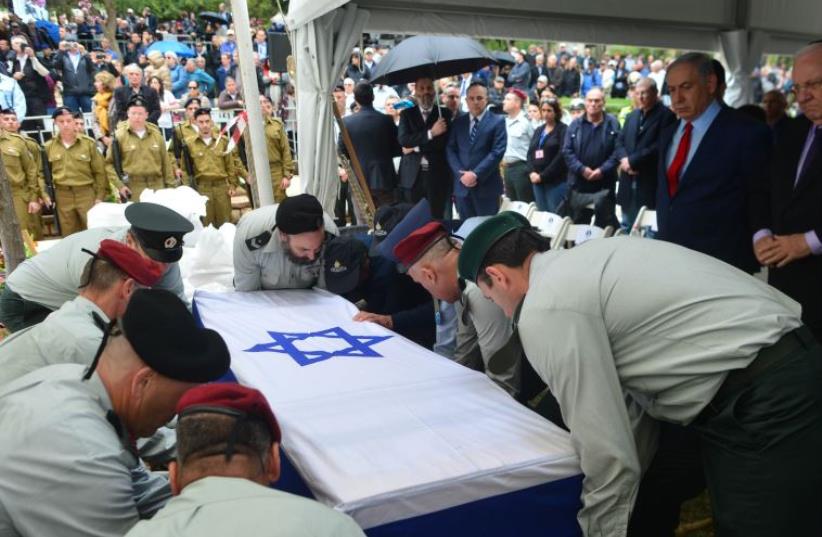 Prime Minister Benjamin Netanyahu and President Reuven Rivlin watch as Meir Dagan is laid to rest in Rosh Pina, Sunday March 20. (photo credit: KOBI GIDON / GPO)