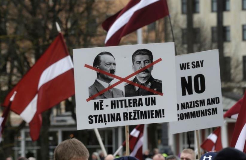 PLACARDS AT the annual procession commemorating the Latvian Waffen-SS unit, also known as the Legionnaires, in Riga on March 16. (photo credit: REUTERS)