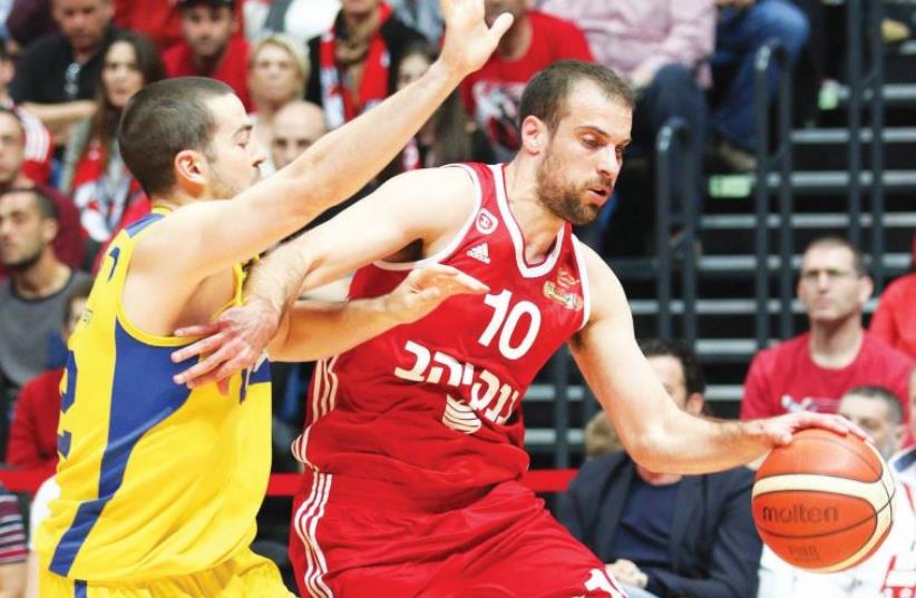 Hapoel Jerusalem guard Yotam Halperin (right) had a game-high 23 points in last night’s 73-66 victory over Taylor Rochestie (left) and Maccabi Tel Aviv at the Jerusalem Arena. (photo credit: DANNY MARON)