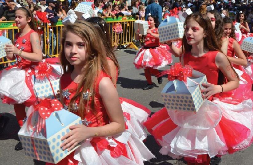 Children proffering mock ‘mishloah manot’ march in last year’s Adloyada parade (photo credit: SHARON HENNESSY)