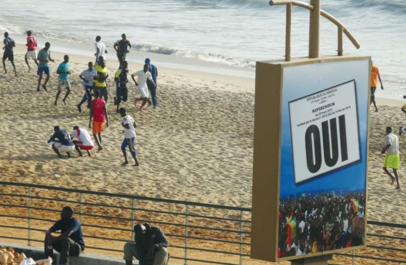 Jogging on the beach is a national sport. The sign encourages people to vote ‘yes’ in a national referendum held on March 20 (photo credit: SETH J. FRANTZMAN)