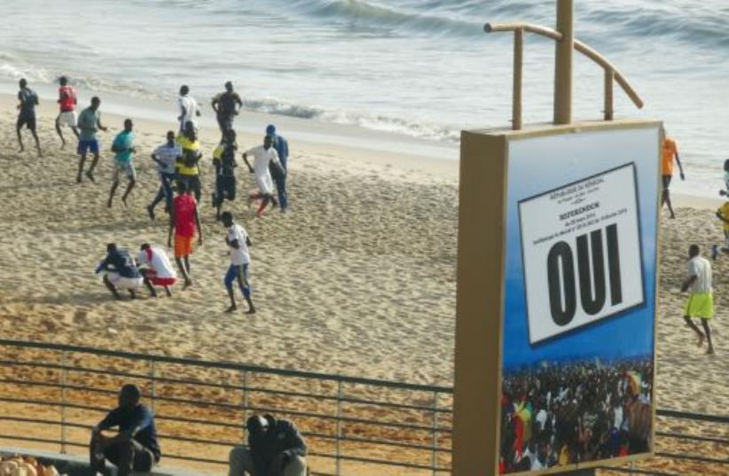 Jogging on the beach is a national sport. The sign encourages people to vote ‘yes’ in a national referendum held on March 20 (photo credit: SETH J. FRANTZMAN)