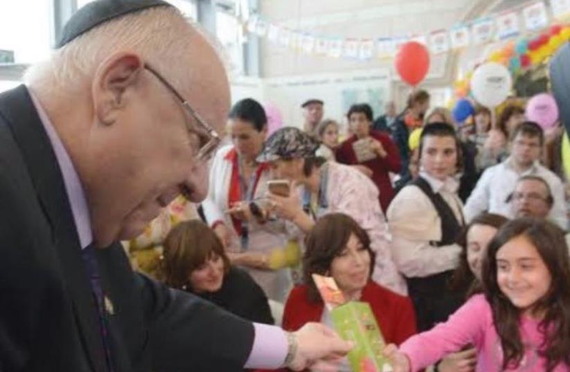 PRESIDENT REUVEN RIVLIN distributes Purim gifts to patients at Hadassah-University Medical Center in Jerusalem’s Ein Kerem earlier this week. (photo credit: Courtesy)