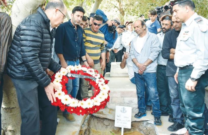 DEFENSE MINISTER Moshe Ya’alon lays a wreath on Brig.-Gen. Munir Amar’s grave in Julis as others look on (photo credit: ARIEL HERMONI / DEFENSE MINISTRY)