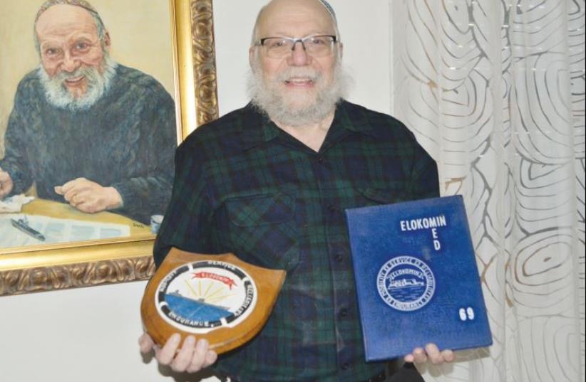 ARYEH WETHERHORN stands next to a self-portrait holding memorabilia from the navy. (photo credit: JUNE GLAZER)