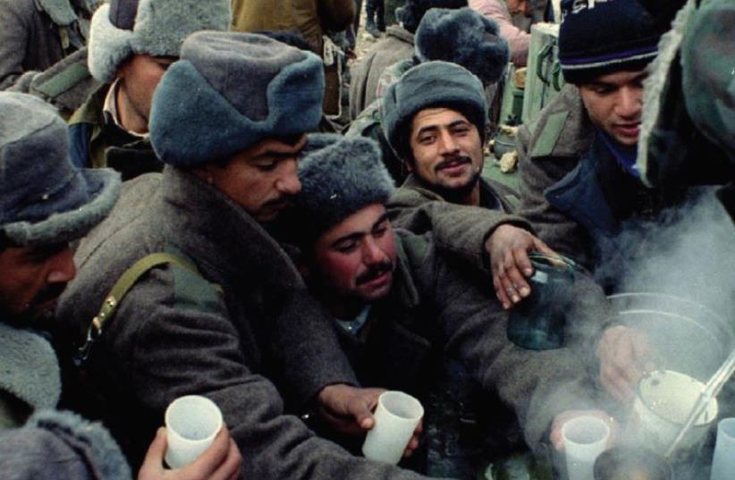 AZERI SOLDIERS crowd around a pot to get some hot tea on the front line between Nagorno-Karabakh guerillas and Azeri troops in the Kelbajar region of the disputed area of Nagorno- Karabakh in 1994. (photo credit: REUTERS)