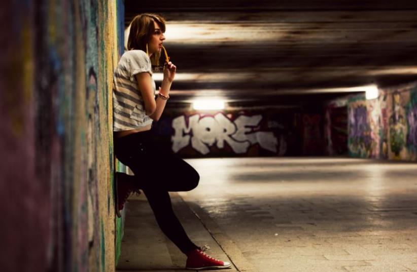 Young girl standing in grunge graffiti tunnel (photo credit: INGIMAGE)