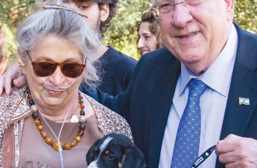 President Reuven Rivlin and his wife, Nechama, spend quality time with a puppy (photo credit: YOAV BEN-DOV AND KHAI HELLER)