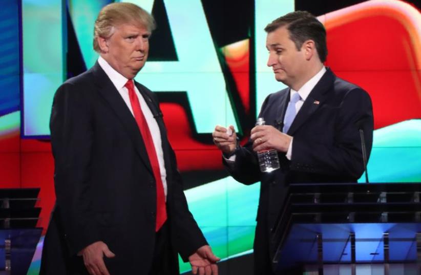 Republican US presidential candidate Donald Trump (L) talks with rival Ted Cruz during a commercial break in the midst of the Republican US presidential candidates debate, March 10, 2016.  (photo credit: REUTERS)