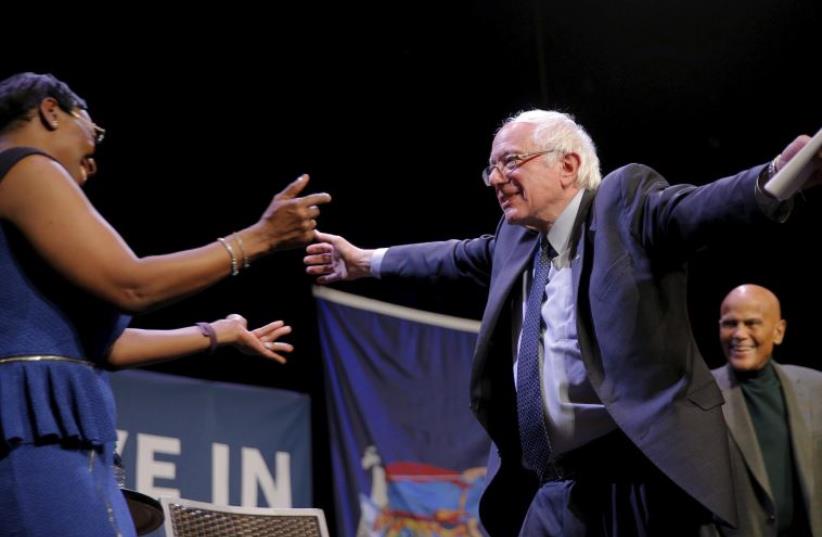 US Democratic presidential candidate and US Senator Bernie Sanders hugs former Ohio State Senator Nina Turner at a campaign "Community Conversation" at the Apollo Theater in Harlem, in New York, New York April 9, 2016. (photo credit: REUTERS)