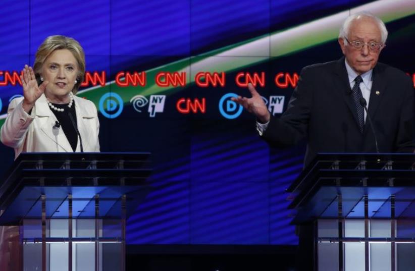 Democratic U.S. presidential candidate Hillary Clinton (L) speaks as Senator Bernie Sanders reacts during a Democratic debate hosted by CNN and New York One at the Brooklyn Navy Yard in New York April 14, 2016. (photo credit: LUCAS JACKSON / REUTERS)
