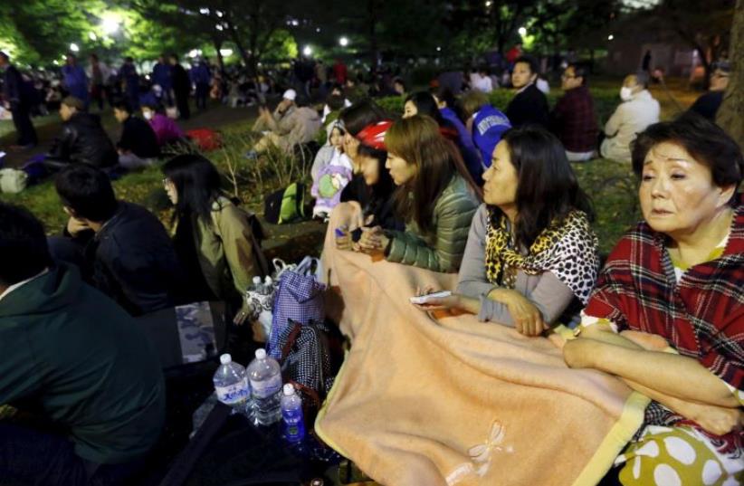 Evacuated residents gather at Shirakawa park after an earthquake in Kumamoto, southern Japan, in this photo taken by Kyodo April 16, 2016. (photo credit: REUTERS)