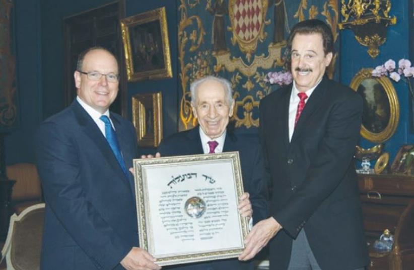 THE PRINCE of Monaco (left) receives an award from former president Shimon Peres and Friends of Zion director Mike Evans. (photo credit: Courtesy)