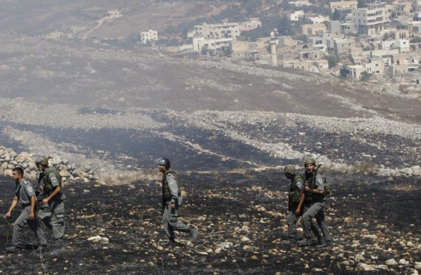 Israeli border police officers walk in the West Bank village of Burin, near Nablus (photo credit: REUTERS)