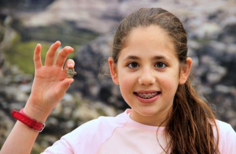 Neshama Spielman, 12, poses with the rare amulet she discovered while volunteering at the Temple Mount Sifting Project. (photo credit: ADINA GRAHAM)