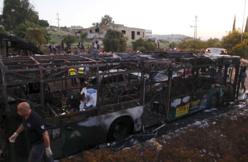 Police forensic experts work at the scene after an explosion tore through a bus in Jerusalem (photo credit: REUTERS)