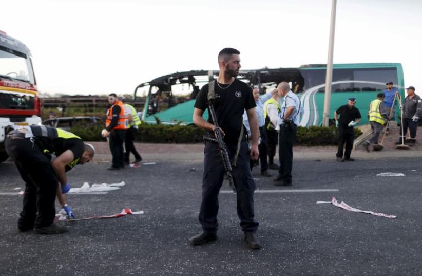 An Israeli police forensic expert works at the scene after a blast on a bus in Jerusalem, April 18, 2016 (photo credit: REUTERS)