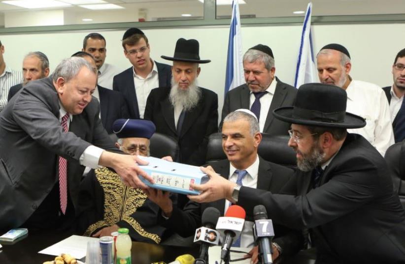ASHKENAZI CHIEF RABBI David Lau hands a box containing the symbolic hametz (leavening) of the State of Israel in a pre-Passover sale to Hussein Jaber from Abu Ghosh. (photo credit: FLASH90)