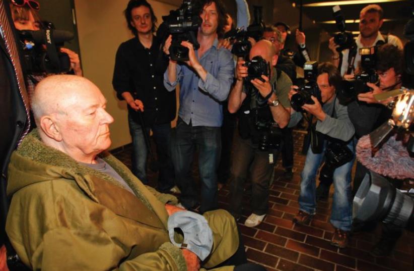 Convicted Nazi death camp guard John Demjanjuk leaves a Munich courtroom after hearing the verdict in his trial, May 12, 2011 (photo credit: REUTERS)