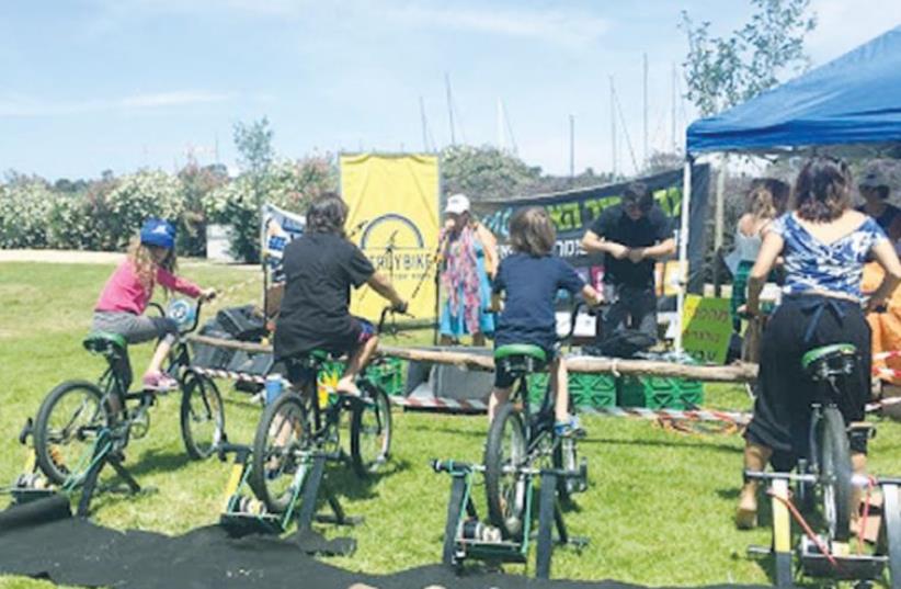 EARTH DAY CELEBRANTS try out electricity-generating bicycles yesterday in Haifa’s Kishon Park. (photo credit: MICHELLE MALKA GROSSMAN)