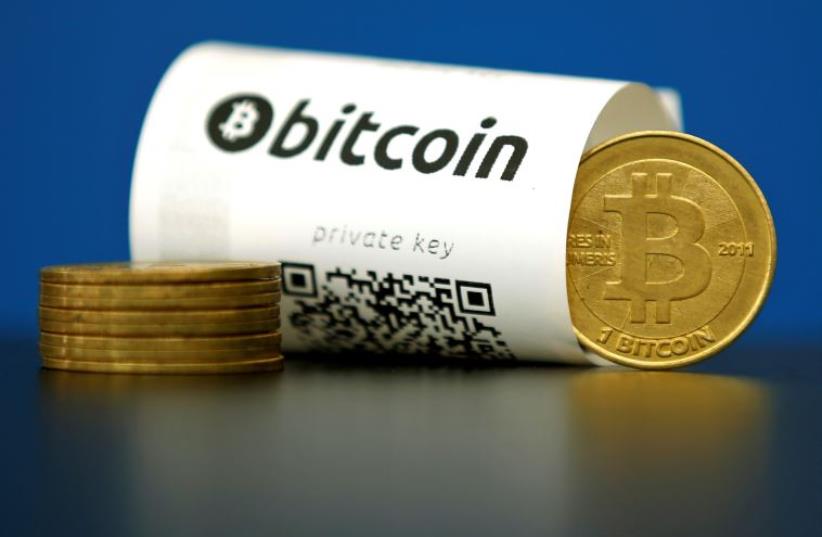 A Bitcoin (virtual currency) paper wallet with QR codes and a coin are seen in an illustration picture taken at La Maison du Bitcoin in Paris, France, May 27, 2015 (photo credit: REUTERS)