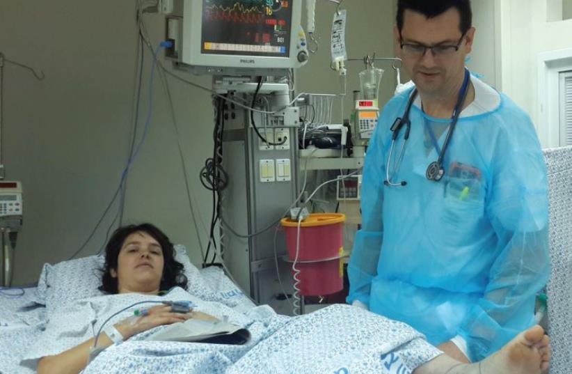 ZIV MEDICAL CENTER intensive care specialist Dr. Ivan Pashkilov yesterday examines Shaked Ben Ami as she recovers from a poisonous snakebite (photo credit: ZIV MEDICAL CENTER)