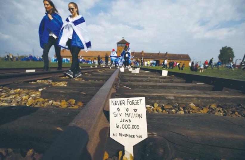 Jewish March of the Living participants walks along the tracks away from the entrance to the Birkenau death camp in May 2016 (photo credit: REUTERS)