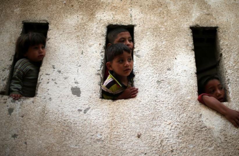 Palestinian boys look out of their house in Beit Lahiya town in the northern Gaza Strip (photo credit: REUTERS)