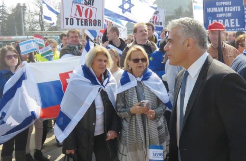Yesh Atid Chairman Yair Lapid attends a pro-Israel rally in front of the UN Human Rights Council in Geneva in March (photo credit: YESH ATID)