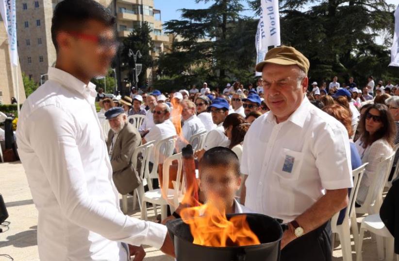 Jewish Agency Chairman Natan Sharansky kindles a memorial flame together with two members of the Nahari family (photo credit: SASSON TIRAM)