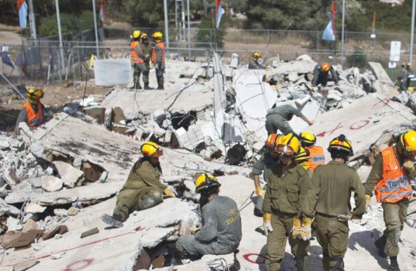 SOLDIERS TAKE part in a drill simulating the rescue of victims from the rubble of a collapsed building as part of a five-day annual home front defense exercise last year. (photo credit: REUTERS)