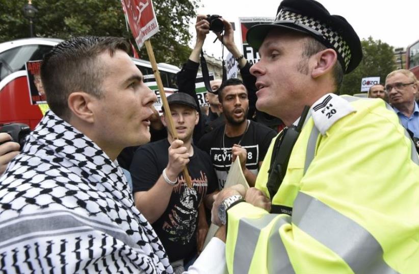 A pro-Palestinian demonstrator argues with police during a protest outside Downing Street in London (photo credit: REUTERS)