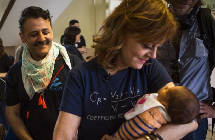 Actress Susan Sarandon holds a refugee baby at Rathaus Wilmersdorf refugee shelter in Berlin (photo credit: ISRAAID)