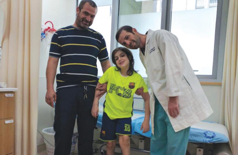 HANA ZEITUN poses recently with his father, Malki, and one of the Shaare Zedek doctors who treated him.  (photo credit: Courtesy)