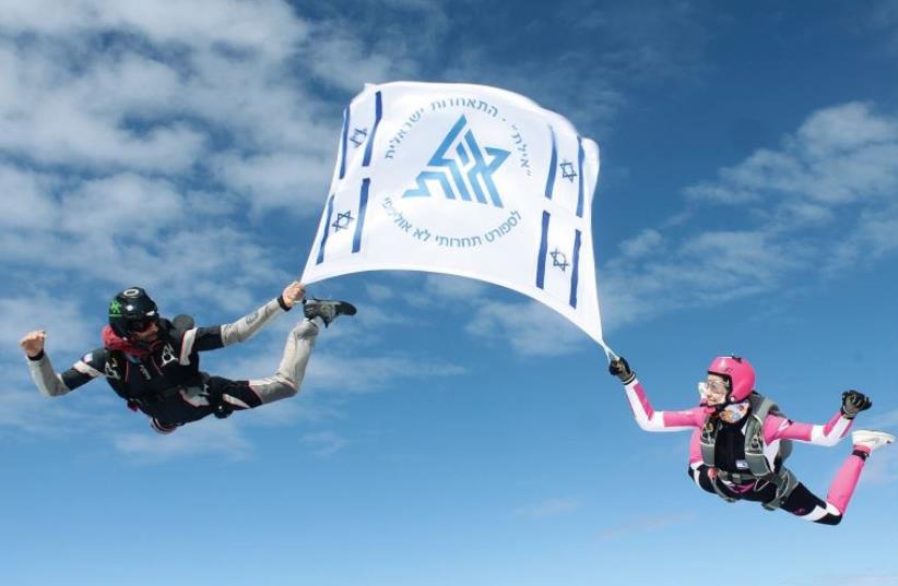 In honor of Independence Day, Gal Peled and Daphne Morali – who hold sixth place in the world in competitive parachuting – jumped from a plane holding the flag of Eilat, decorated with Israeli flags (photo credit: YEVGENY YERMAKOV)