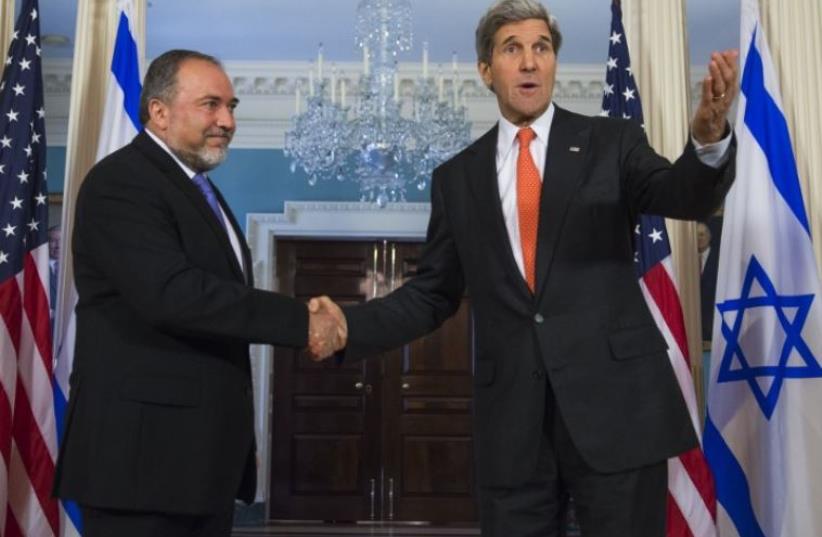 US Secretary of State John Kerry (R) and then-foreign minister Avigdor Liberman shake hands in Washington (photo credit: AFP PHOTO)