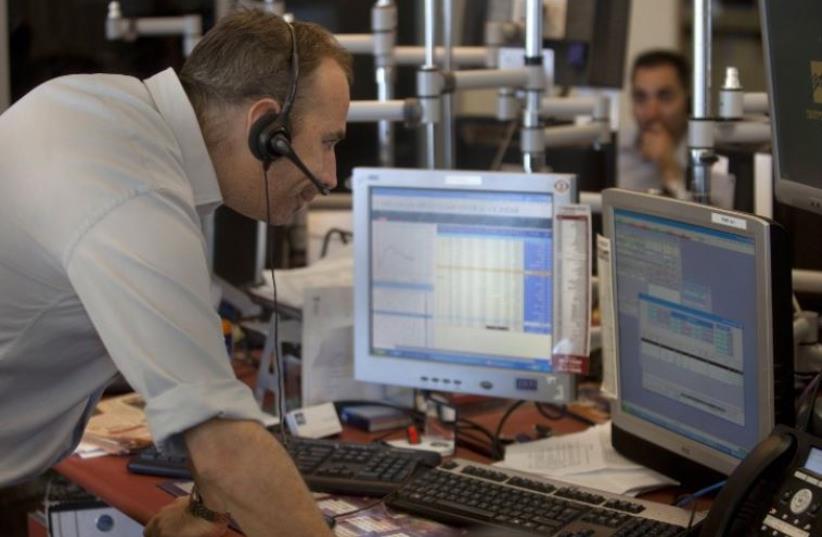 Israeli stock market traders work at their office in the Meitav investment house in Tel Aviv (photo credit: AFP PHOTO)