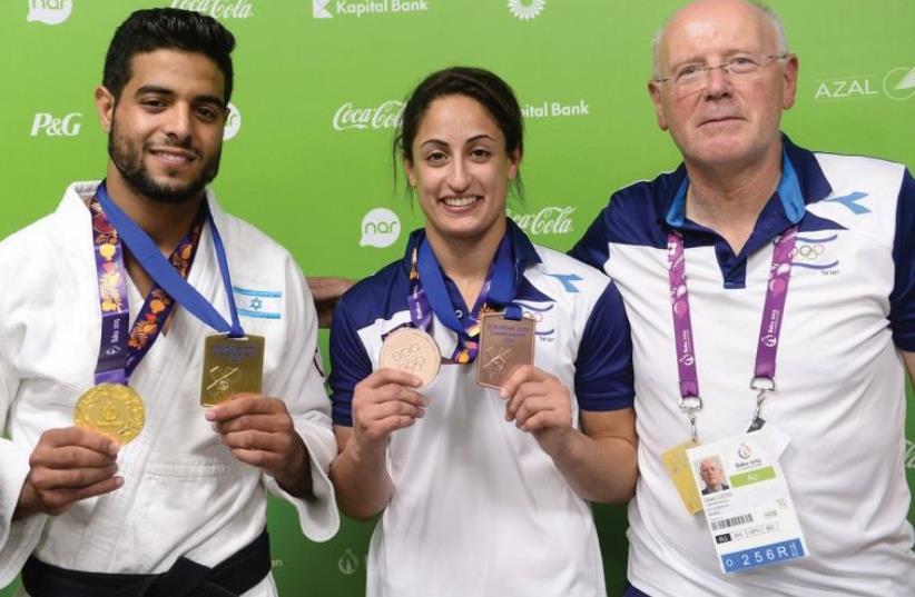 Gili Lustig, Secretary General of the Olympic Committee of Israel, poses with Sagi Muki, who won judo gold at the 2015 European Games in Baku, and Yarden Gerbi, who won bronze (photo credit: AMIT SHIESEL / COURTESY OLYMPIC COMMITTEE OF ISRAEL)